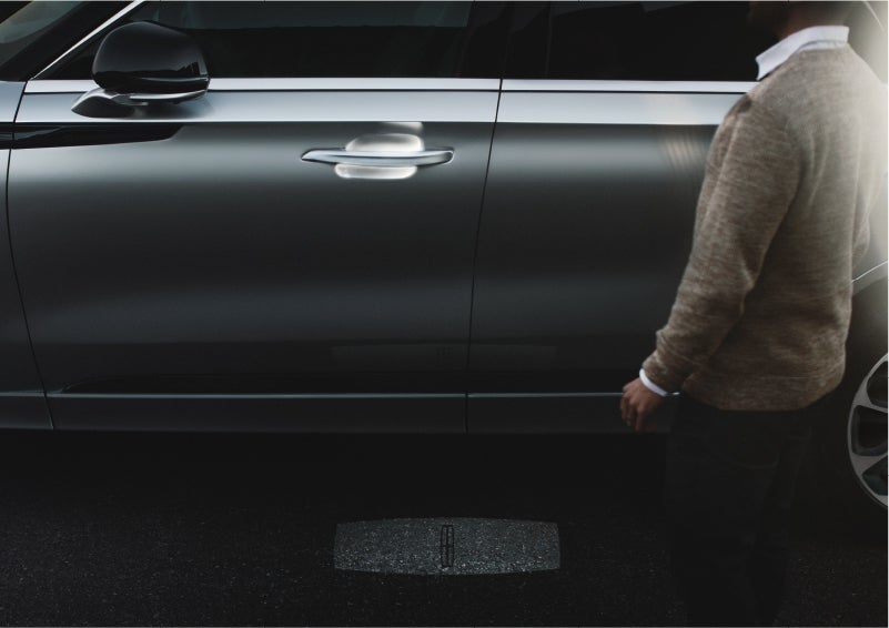 A person approaches a 2023 Lincoln Aviator® Grand Touring as the Lincoln Embrace sequence of welcome lighting illuminates | Lincoln Demo 2 in Wooster OH
