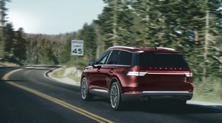 A 2024 Lincoln Aviator® SUV is being driven on a winding mountain road | Lincoln Demo 2 in Wooster OH