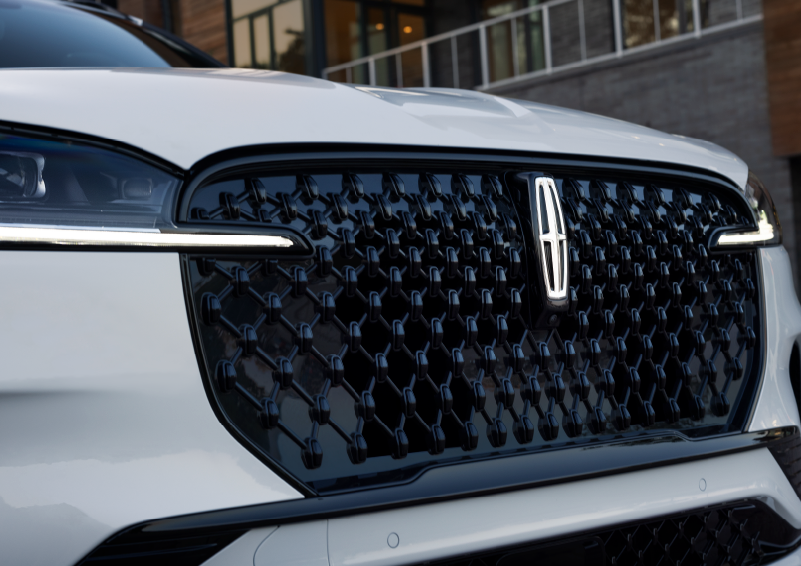 The black grille of a white 2025 Lincoln Aviator® SUV is shown with its fog lights on. | Lincoln Demo 2 in Wooster OH